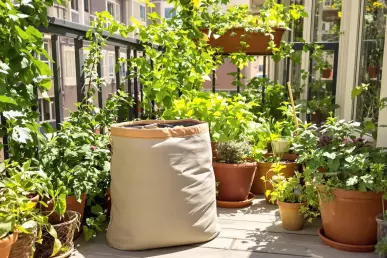 Un sac à compost posé sur un balcon en ville